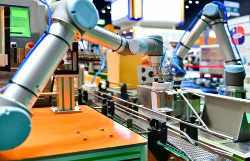 Robot arm arranged glass water bottle on Automatic industrial machinery equipment in production line factory